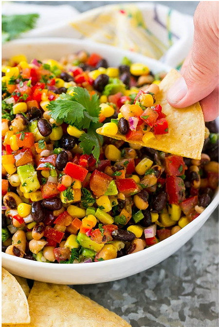 cowboy caviar in bowl with chip held by nutritionist
