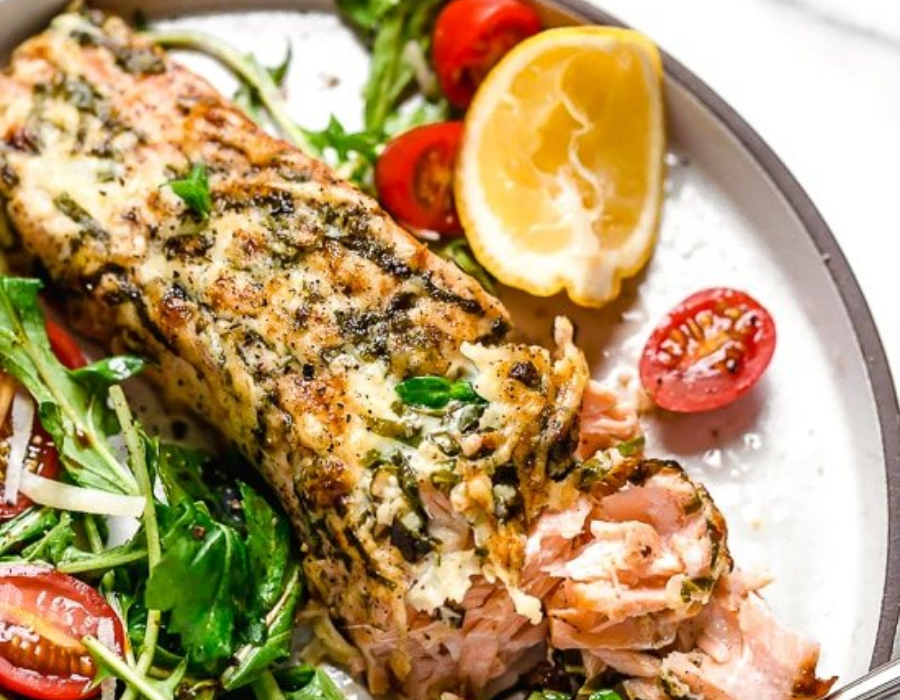 basil parmesan crusted salmon on a plate with lemon and tomato