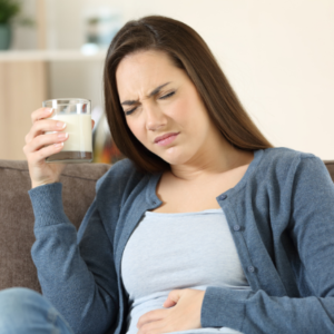 women holding her stomach in pain after consuming lactose products