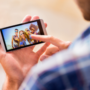man using his phone to look at how him and his friends look on photo