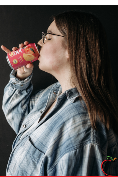 woman drinking a diet soda wearing denim shirt
