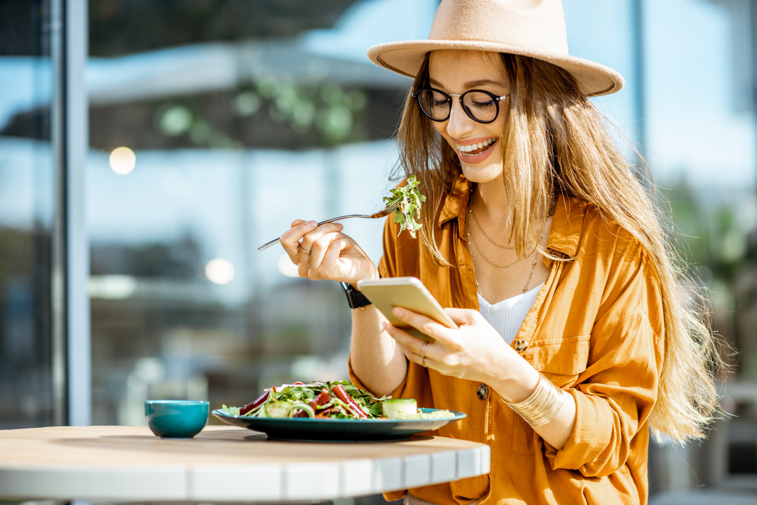 woman eating a salad according to her meal plan prepared by a nutritionist