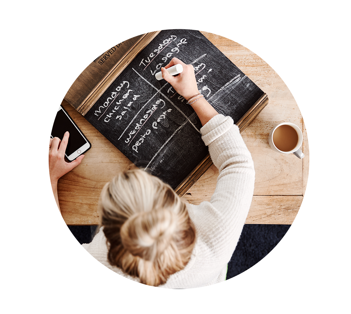 woman writing our her nutritious meal plan on chalkboard