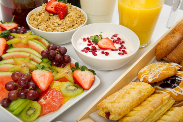 hotel breakfast of fruit, oatmeal, yogurt, and pastries