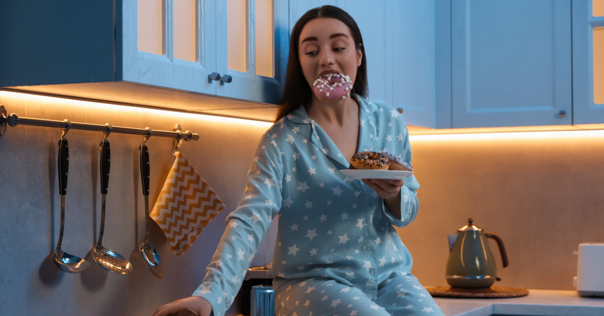 Girl sitting on counter eating a late night snack of donuts and pizza