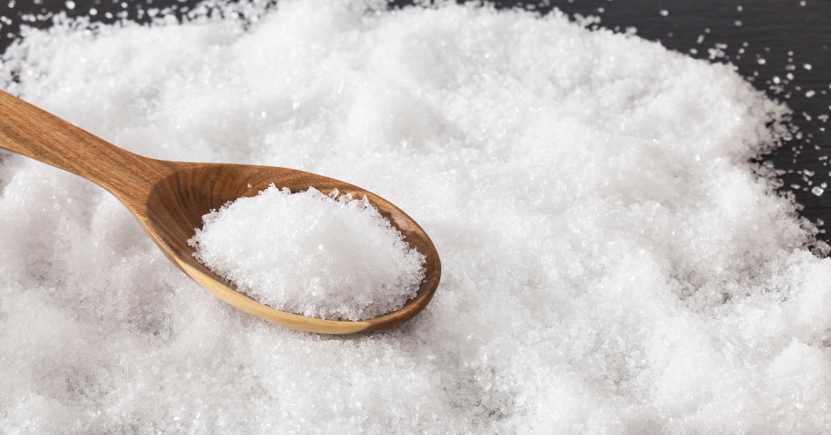 salt on a spoon on a table full of salt