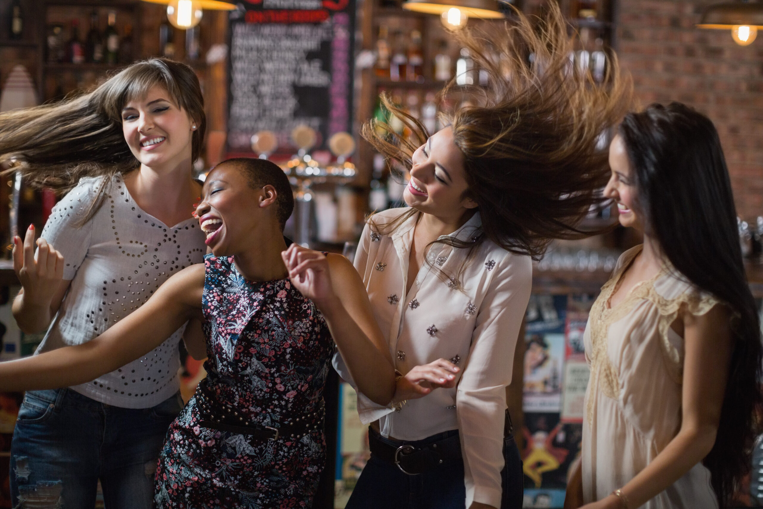 Carefree female friends dancing at pub Carefree female friends dancing at pub