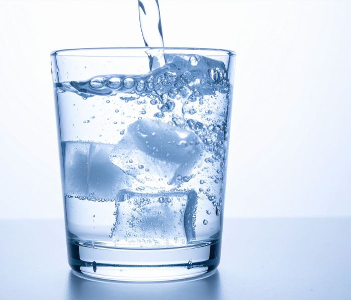water pouring into a glass with ice